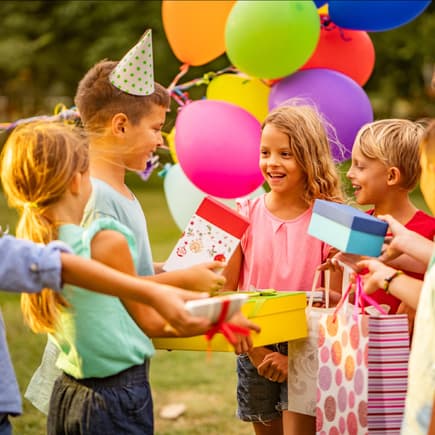Kinder überreichen ihre Geschenke beim Kindergeburtstag