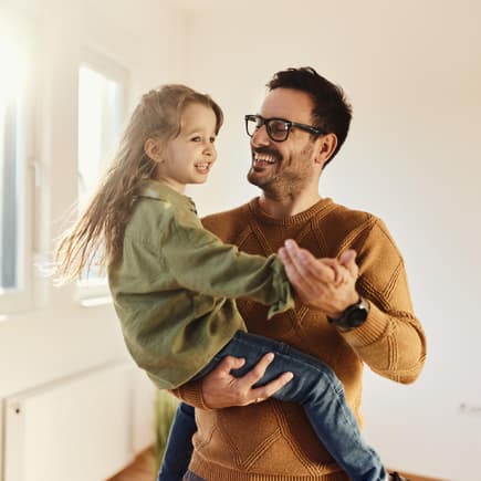 Lachender Vater trägt seine Tochter.