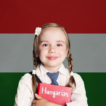 Kleines Mädchen mit Zöpfen vor der ungarischen Flagge.