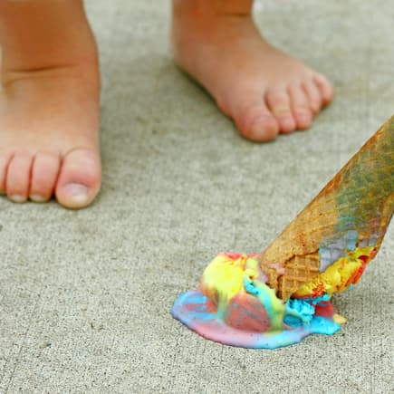 Nackte Kinderfüße, ein Eis liegt auf dem Boden