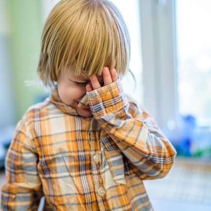 Kleiner Junge weint beim Abschied von Eltern. 