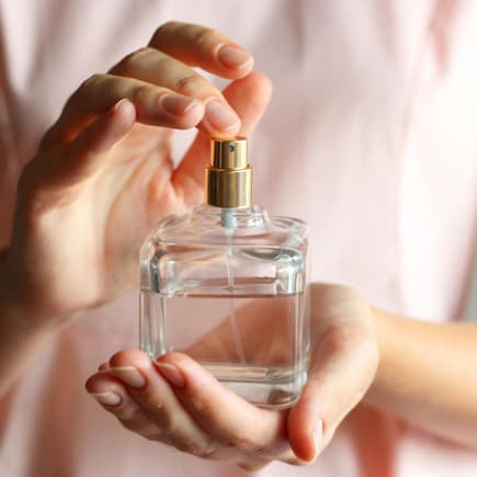 Eine Mutter hält eine Flasche Baby-Parfum in den Händen