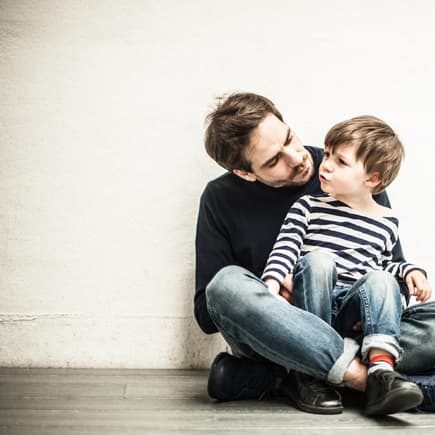 Sohn sitzt bei seinem Vater auf dem Schoß.