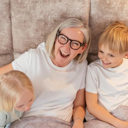 Oma lacht mit ihren beiden Enkeln.