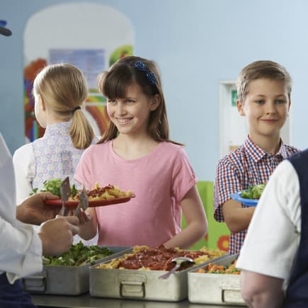 Kinder holen sich Essen in der Schulkantine.