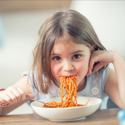 Ein Kind, das Spaghetti isst.