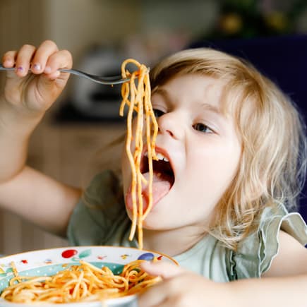 Kind isst Spaghetti.
