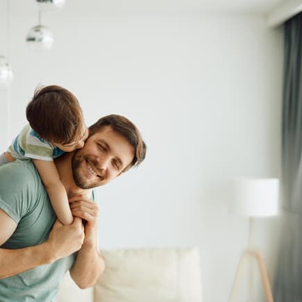 Vater trägt seinen Sohn auf dem Rücken.