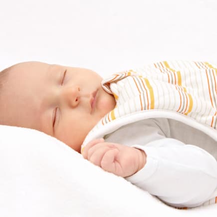 Ein Baby schläft im Winter im Schlafsack. 