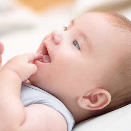 Baby saugt an seinem Finger – typisch für die orale Phase.