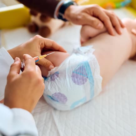 Baby wird in den Oberschenkel geimpft.