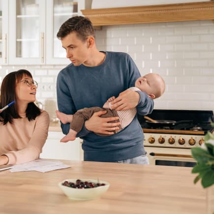 Junge Eltern mit Baby besprechen das Thema Finanzen.