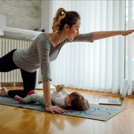 Eine Mama macht nach der Geburt Beckenbodentraining mit ihrem Baby. 