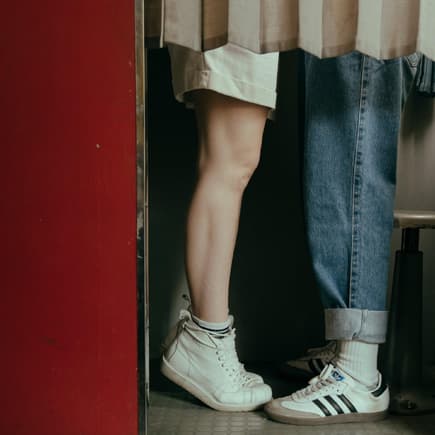Jugendliche küssen sich – man sieht nur ihre Beine.