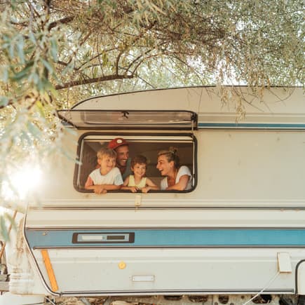 Familie schaut aus Wohnmobil-Fenster