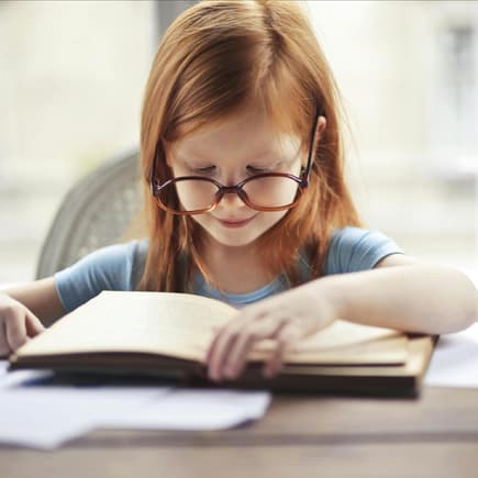 Kleines Mädchen liest ein Buch.
