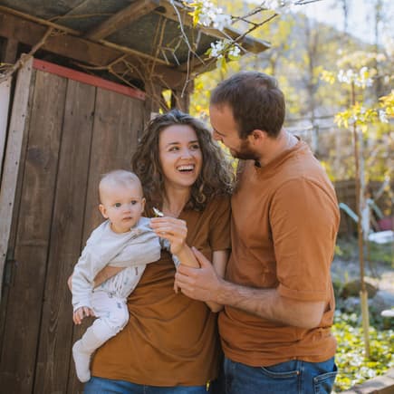 Glückliche Familie draußen mit Baby.