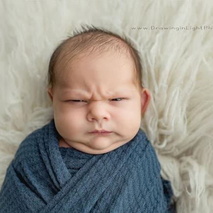Ein Baby, das mürrisch guckt.