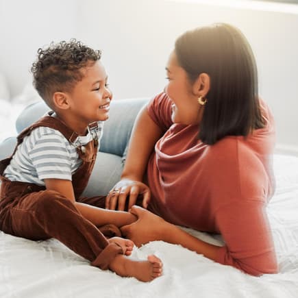 Mutter und Sohn liegen auf dem Bett und unterhalten sich.