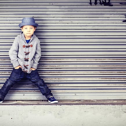 Kleiner Junge in mit Hut posiert cool.