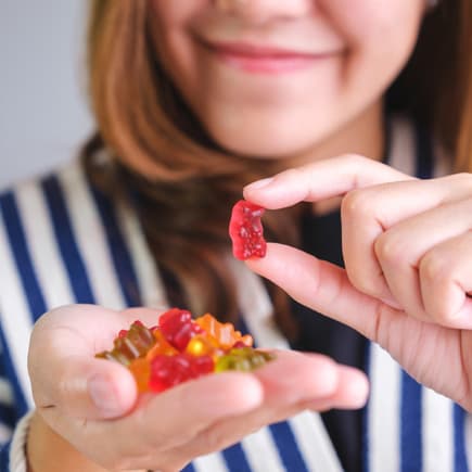 Eine Frau hält Gummibärchen in der Hand