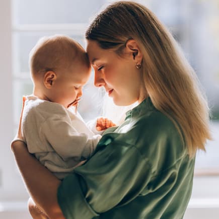 Mutter hält ihr Baby liebevoll auf dem Arm.