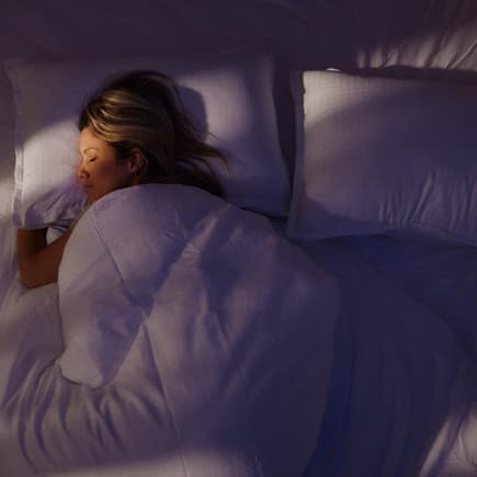 Eine Frau, die allein im Doppelbett schläft