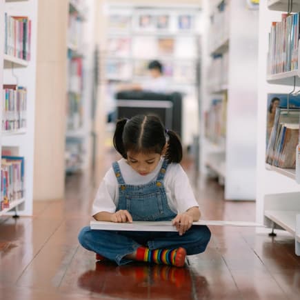 Mädchen liest in Kinderbuchhandlung.