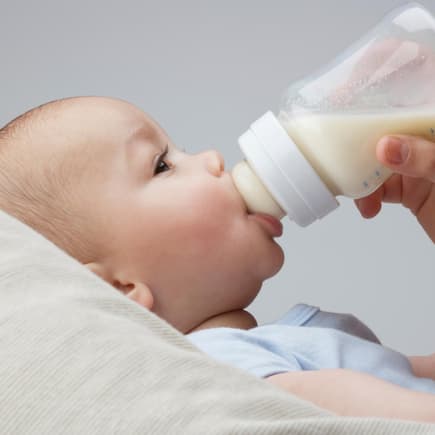 Baby trinkt Milch aus der Flasche.