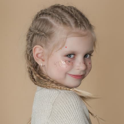 Ein Mädchen mit vielen kleinen geflochtenen Zöpfen