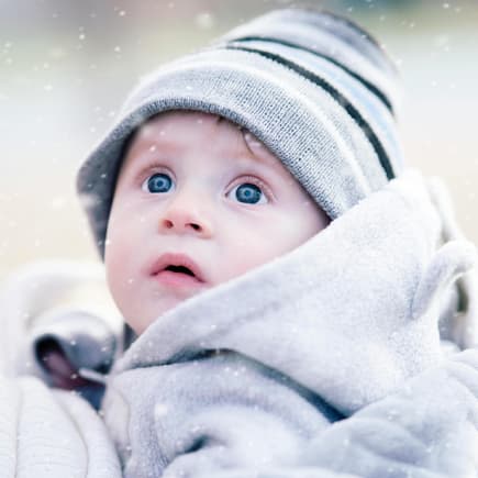 Kleiner Junge staunt über Schneeflocken.