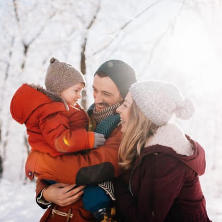 Lachende Familie im Schnee.