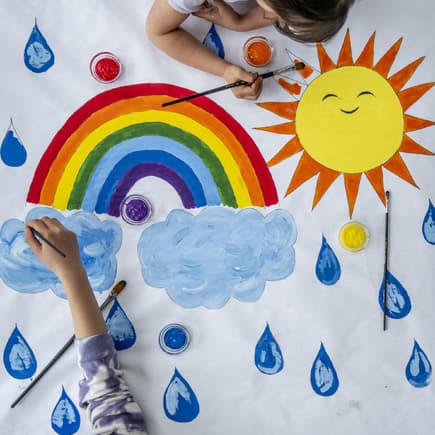 Kinder malen Regenbogen.