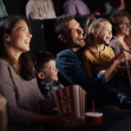 Lachende Familie im Kino.
