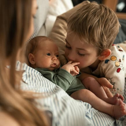 Geschwisterchen begrüßt das neue Baby.