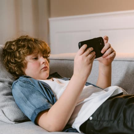Junge spielt auf dem Smartphone.