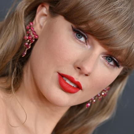 Porträt von Taylor Swift mit roten Ohrringen.