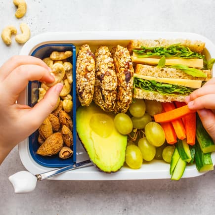 Brotdose mit Kinderhänden.