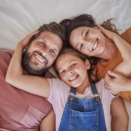 Glückliche Familie liegt im Bett.