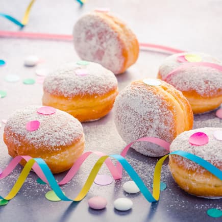 Berliner mit Puderzucker, Luftschlangen und Konfetti.