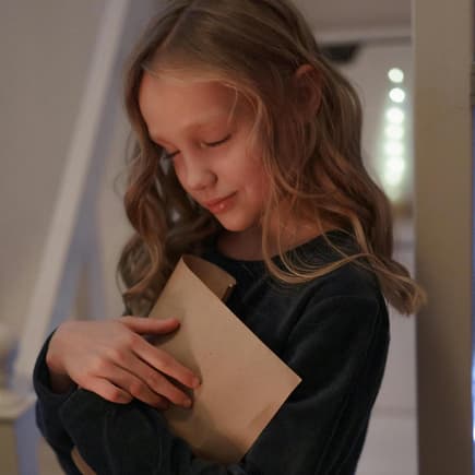 Mädchen hält liebevoll einen Brief in der Hand.
