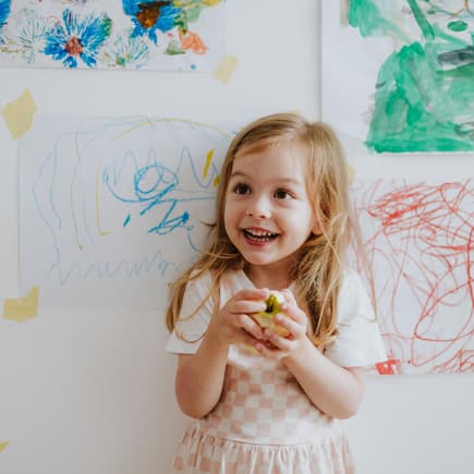 Mädchen mit Apfel in der Hand.