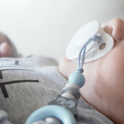 Keine Nuckel-Suche mehr! Eine Schnullerkette kann – praktisch – am Body des Babys befestigt werden.