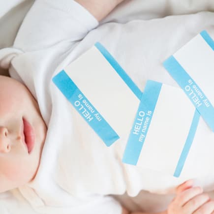 Baby im Wickelbody mit Namensaufklebern