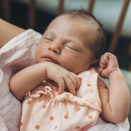 Mutter hält kleines Baby auf dem Arm.