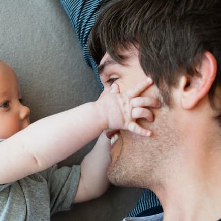 3 Monate altes Baby erforscht das Gesicht seines Vaters