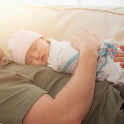 Für den Einstieg das Baby in der Liegeposition in den Arm nehmen und es in den Schlaf summen.