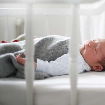 Baby schläft im Bettchen.