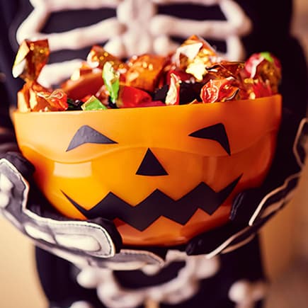Kind hält Halloween-Schale.