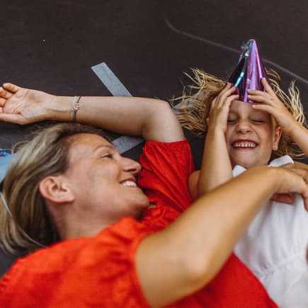 Mutter und Kind liegen auf Trampolin.